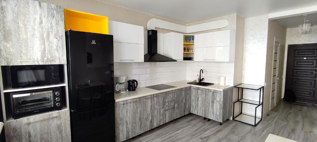a kitchen with a black and white kitchen at Апартаменты в ЖК " 30я Жемчужина KADORR" in Liski