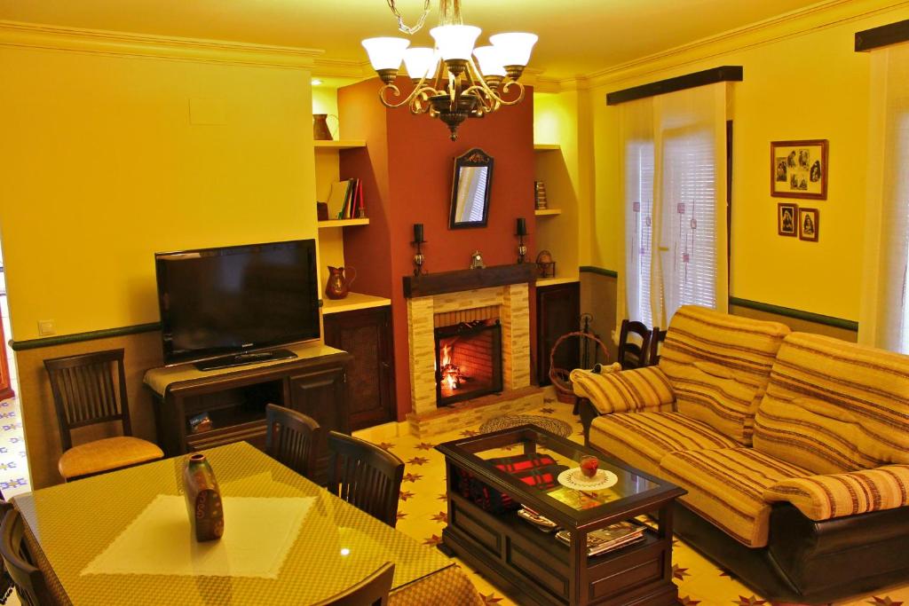 sala de estar con sofá y chimenea en Casa Aurora, en Carcabuey