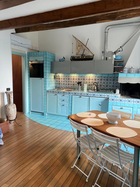a kitchen with blue cabinets and a wooden floor at Elegant apartment with sea view in Monterosso al Mare