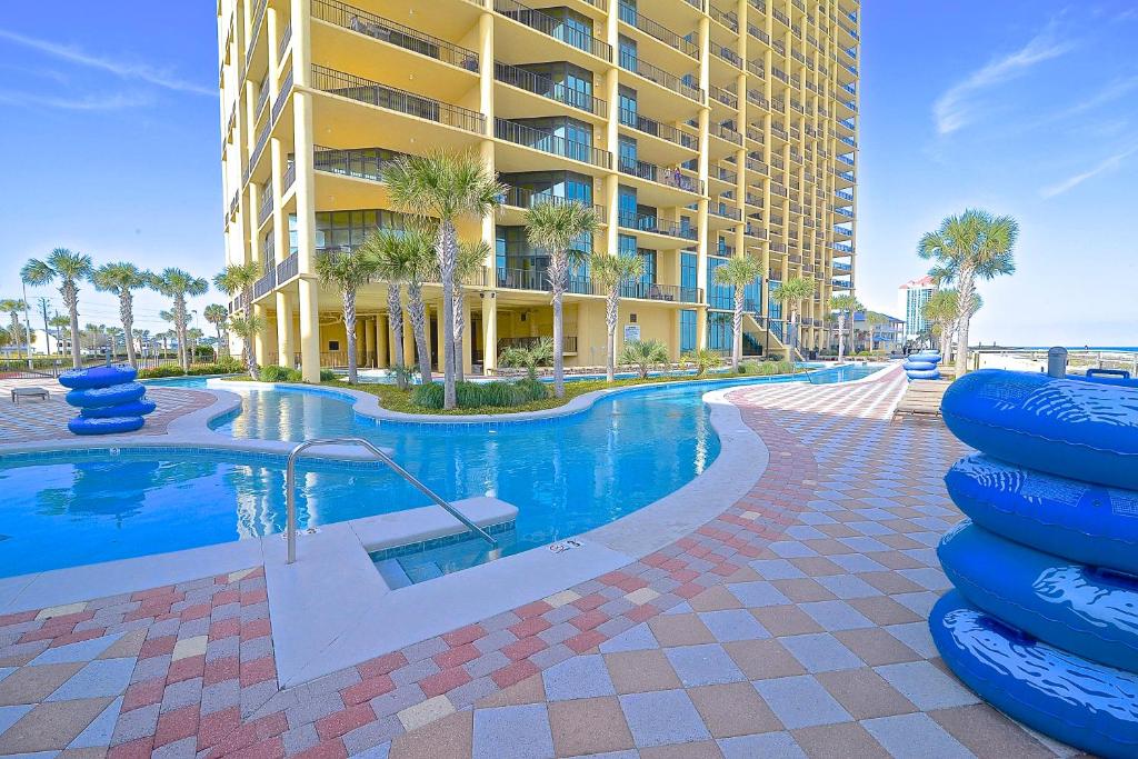 a swimming pool in front of a large building at Oasis at Orange Beach 1103 in Orange Beach