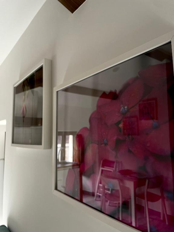 a wall with a picture of a table with pink chairs at Marujita Vilanova, alojamiento singular in Villanueva de Arosa