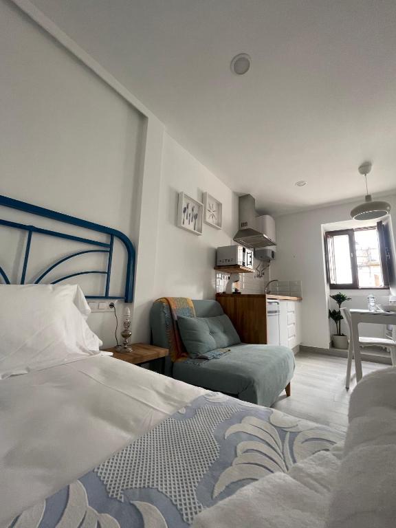 a bedroom with a bed and a living room at Marujita Vilanova, alojamiento singular in Villanueva de Arosa