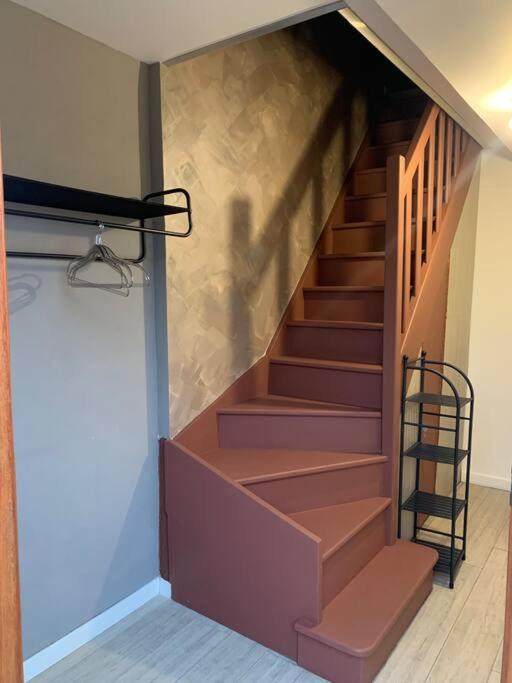 a staircase in a house with brown steps at Appartement équipé pour 5 pers in Vénissieux