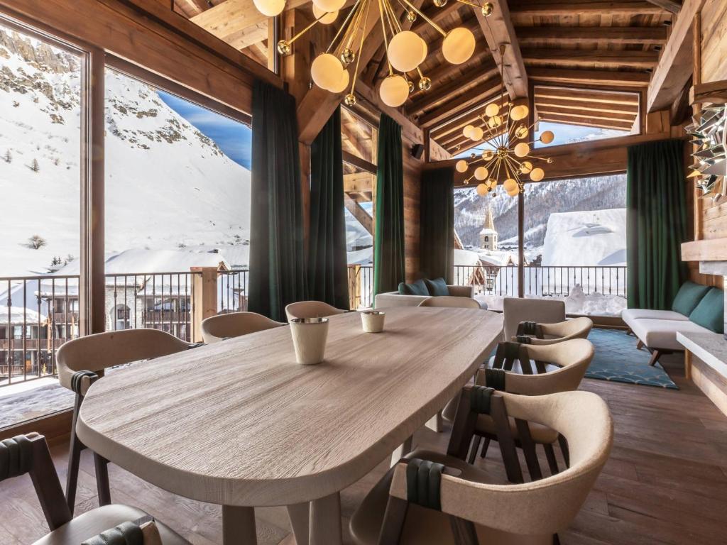 - une table et des chaises en bois dans une chambre avec des montagnes dans l'établissement Duplex 5 pièces luxe aux pieds des pistes avec hammam et cheminée - FR-1-694-87, à Val dʼIsère
