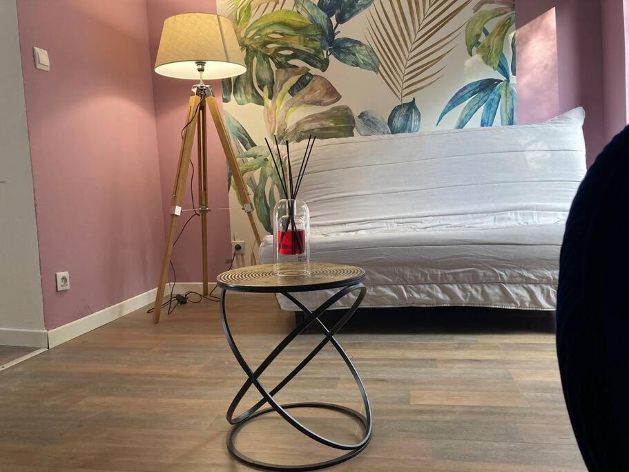 a table with a lamp and a bed in a room at Au Bois d'Epenin - Gite et Spa in Beugin