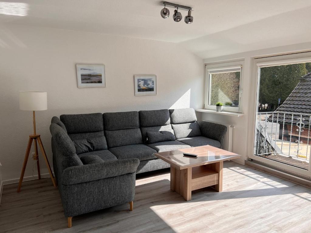 ein Wohnzimmer mit einem Sofa und einem Tisch in der Unterkunft Großzügige 3 ZKB mit 80m² in Wilhelmshaven