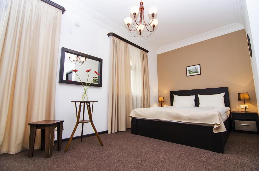 Habitación de hotel con cama y lámpara de araña. en City Centre Hotel By Picnic, en Ereván