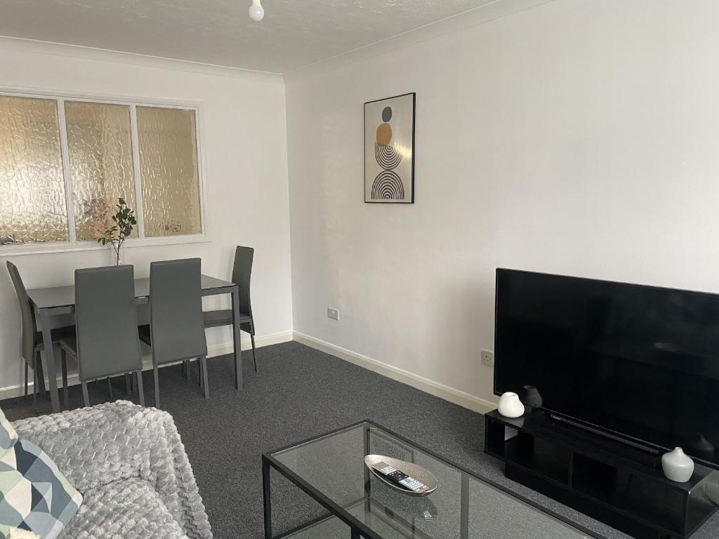 un soggiorno con divano e tavolo con TV di Spacious Apartment - Contractors and Family - LGW a Horley