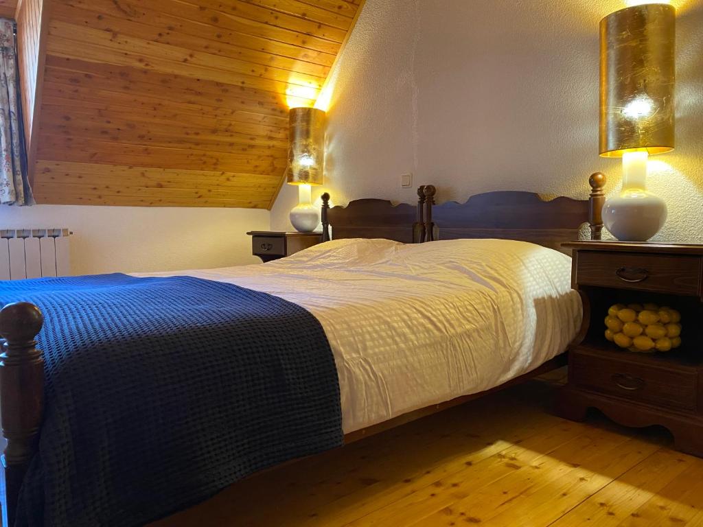 sypialnia z łóżkiem i drewnianym sufitem w obiekcie Luxurious Townhouse Petelin w mieście Plužna