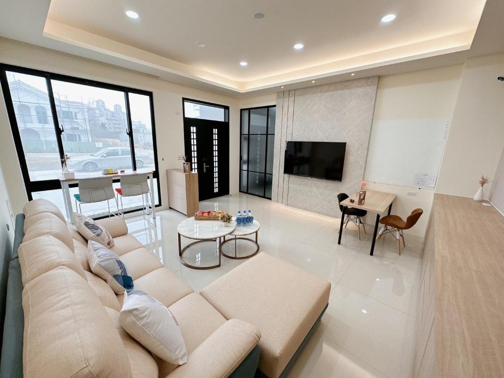 een grote woonkamer met een bank en een tv bij 芸樂行旅 in Magong