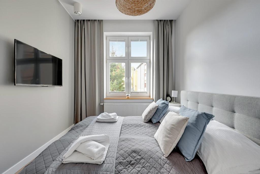 una camera da letto con un grande letto con cuscini blu di Skandynawski - 4 osobowy apartament przy Monte Cassino by Grand Apartments a Sopot