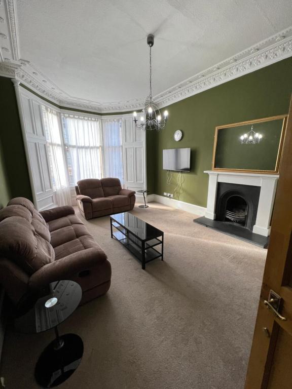 a living room with a couch and a fireplace at Sauchiehall Street West End Apartment in Glasgow
