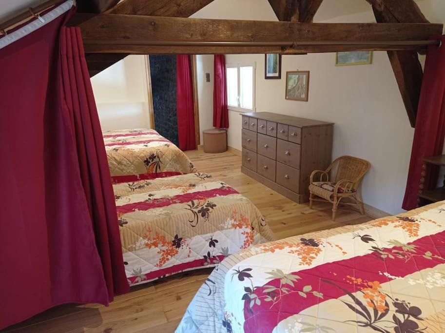1 dormitorio con 2 camas y suelo de madera en Chez Ophélie, en Saint-Bazile-de-Meyssac