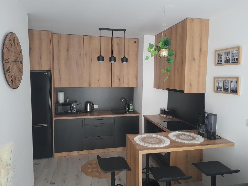 a kitchen with wooden cabinets and a table and chairs at Apartament Amelia in Zamość