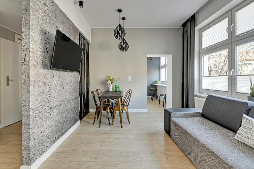 a living room with a couch and a table at Loft Apartment Haffnera Sopot by Grand Apartments in Sopot