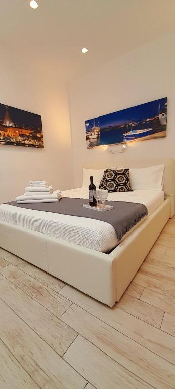 duże białe łóżko w sypialni ze stołem w obiekcie BARBARA Classy Apartment 101 w Syrakuzach