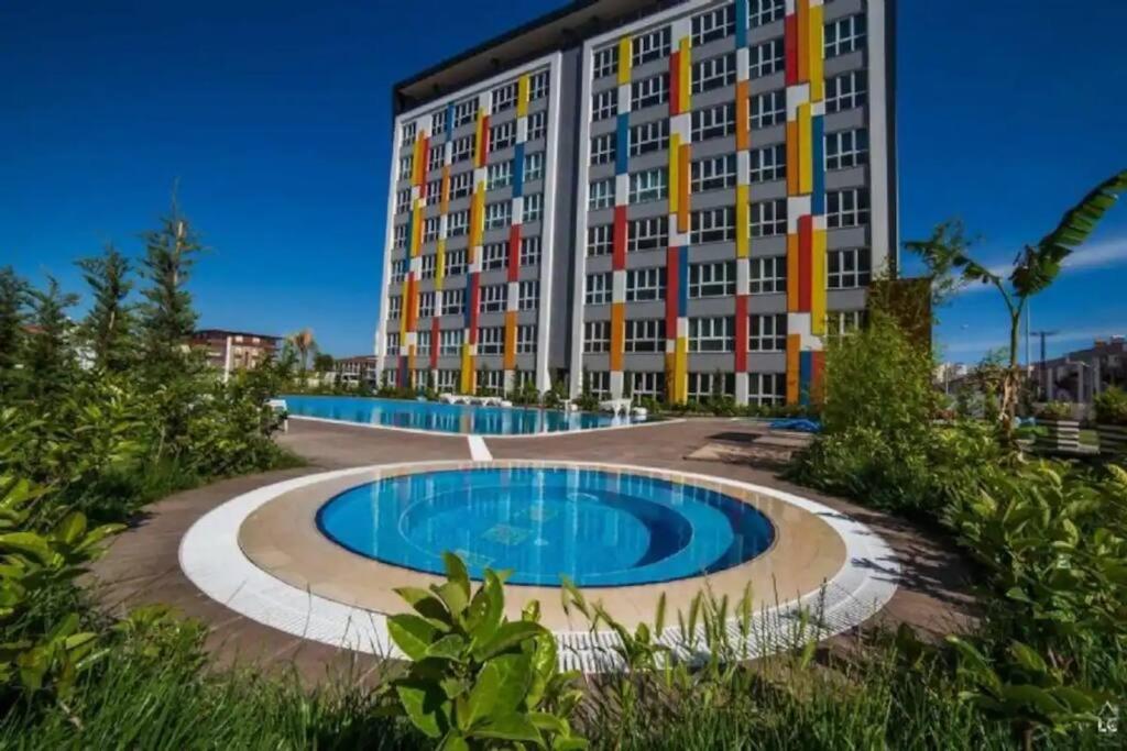 ein Gebäude mit einem Pool vor einem Gebäude in der Unterkunft Luxury Holiday - Spa, Olympic Pool, Fitness, Sauna No88 in Antalya