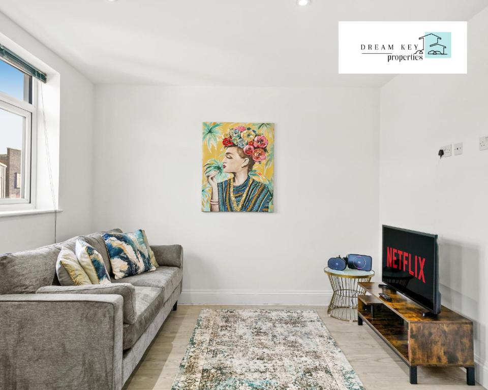 una sala de estar con sofá y una pintura en la pared en Two Bedroom Apartment by Dream Key Properties Short Lets & Long Lets Uxbridge- 6, en Uxbridge