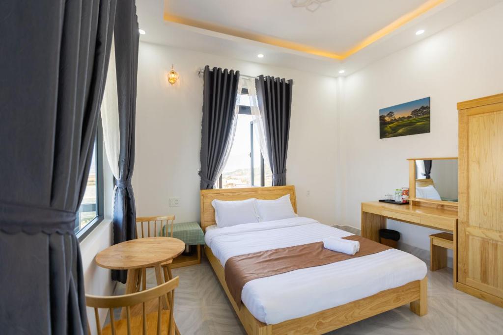 Hải Âu Villa Hotel في Ấp Kim Thạch: غرفة نوم بسرير ومكتب ونافذة
