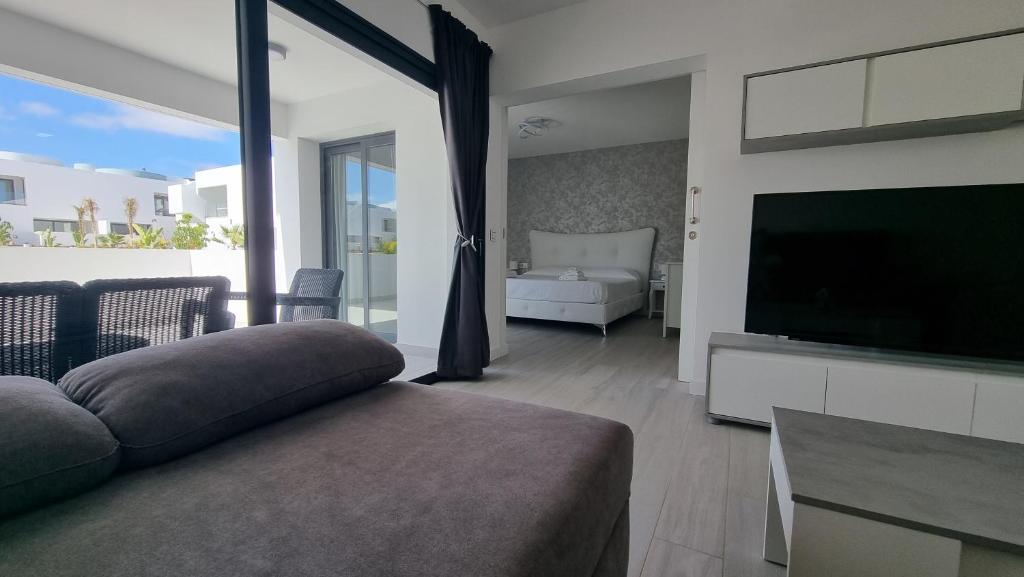 Casilla de Costa Luxury home في لا أوليفا: غرفة معيشة مع أريكة وتلفزيون بشاشة مسطحة