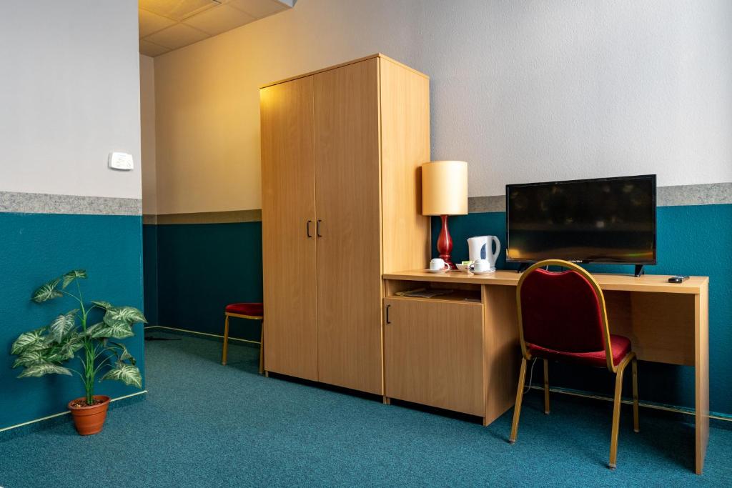 Televízia a/alebo spoločenská miestnosť v ubytovaní Gartner Hotel