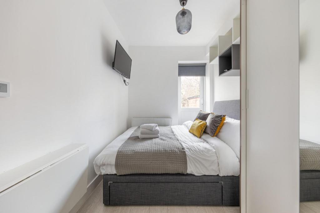 a bedroom with a bed and a window at Functional Double With An Ensuite Toilet And Shower Near Tube And Bus Stations in London