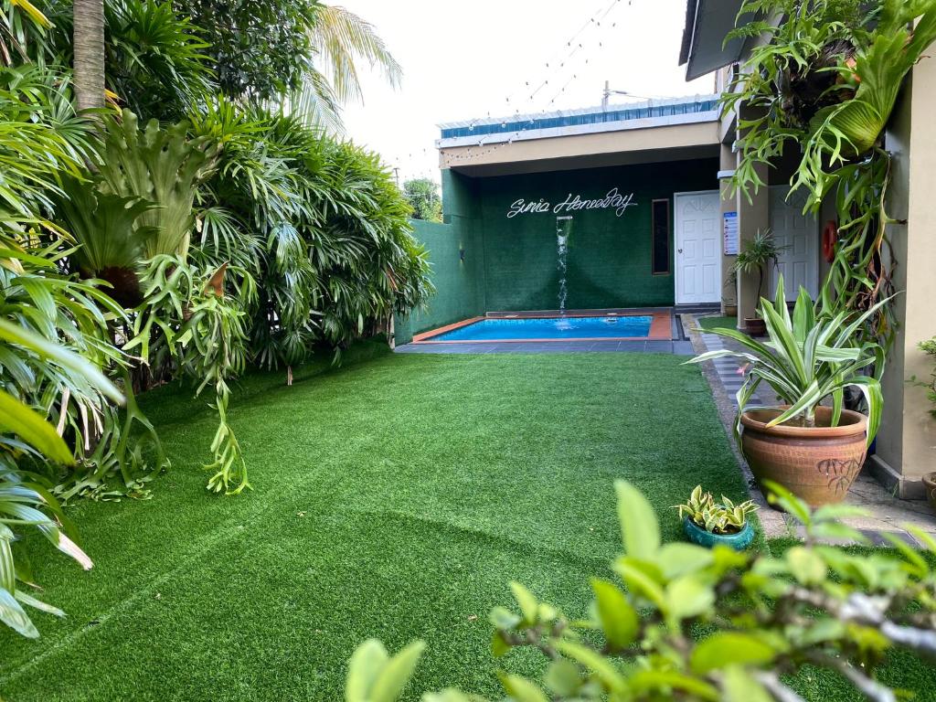 a backyard with a green lawn and a swimming pool at Suria 1 Homestay JB with Private Pool in Johor Bahru