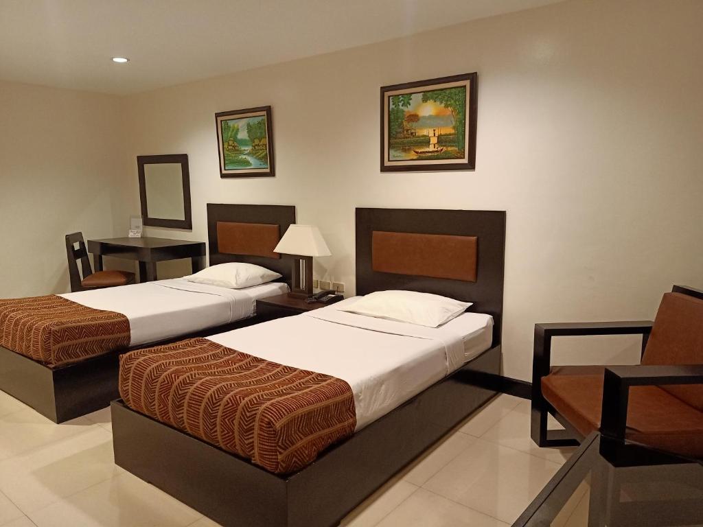 Habitación de hotel con 2 camas y mesa en Paragon Tower Hotel en Manila