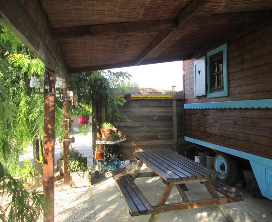a patio with a picnic table and a house at La roulotte des Carpates in Gaillac