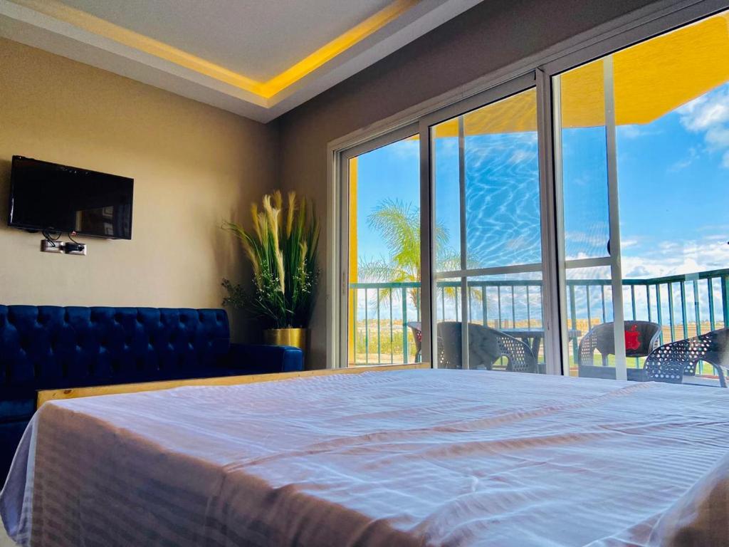 a bedroom with a large bed and a large window at Porto marina chalet and apartment in El Alamein