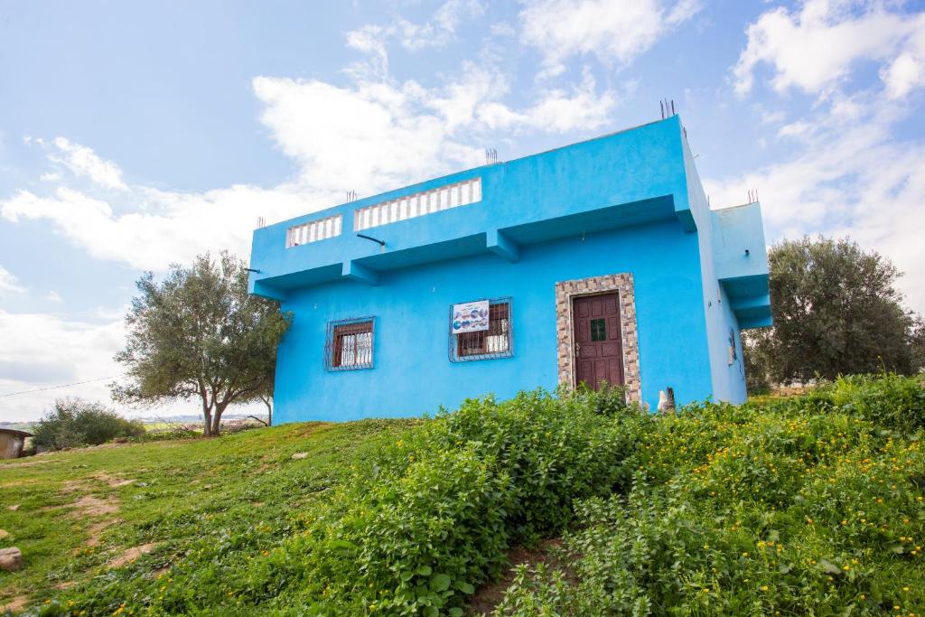 a blue house on top of a hill at La belle vue in Daher