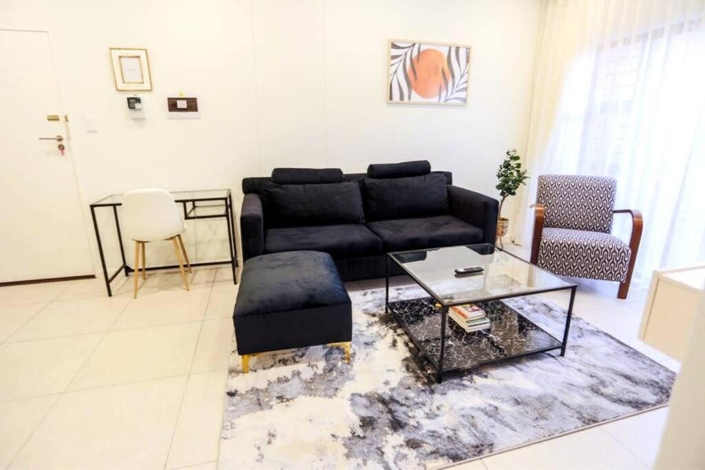 un soggiorno con divano nero e tavolo di Lovely morden 1 bedroom cozy apartment a Lombardy East