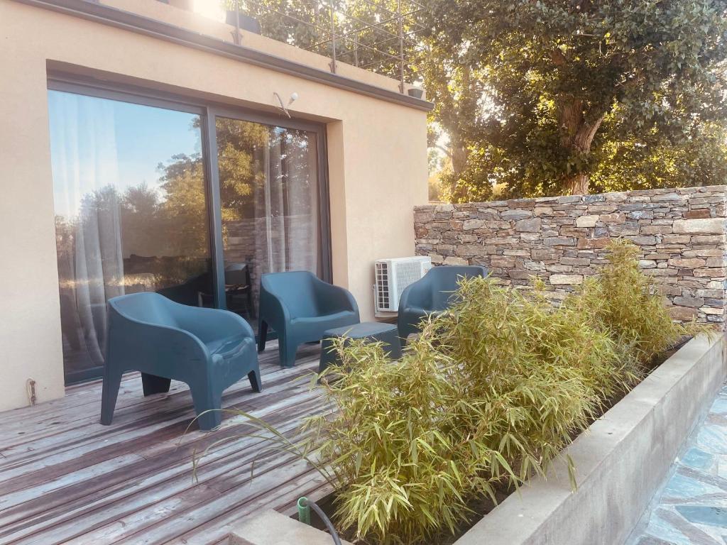 une terrasse en bois avec des chaises bleues dans l'établissement T3 dans charmante propriété, à Borgo