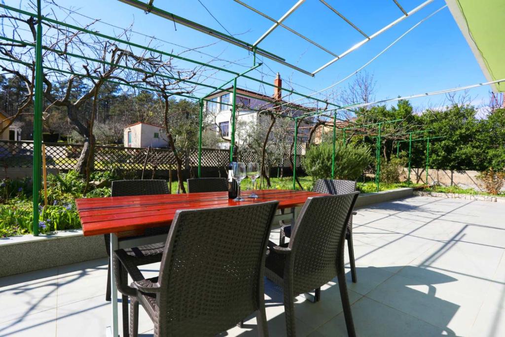 een houten tafel en stoelen op een patio bij Apartment Rozman in Vozilići