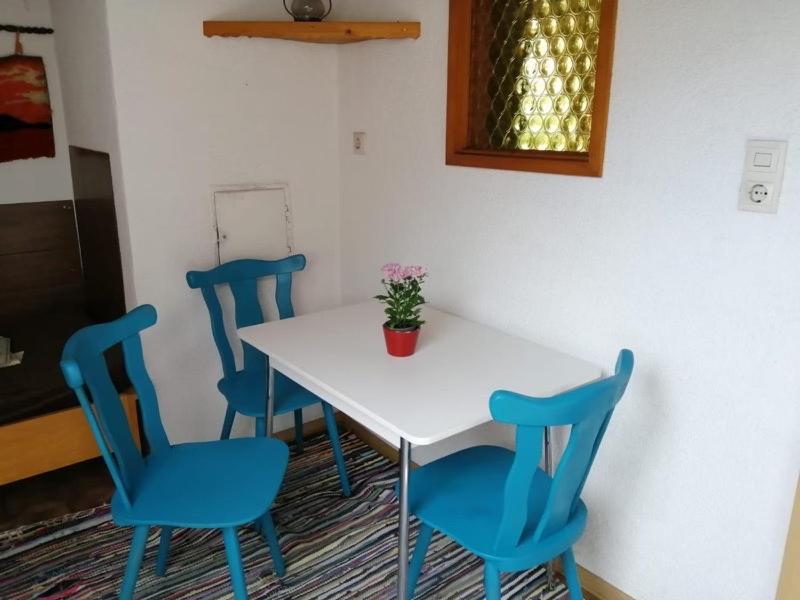 a white table with blue chairs and a potted plant on it at Haus Mali in Heiligenberg