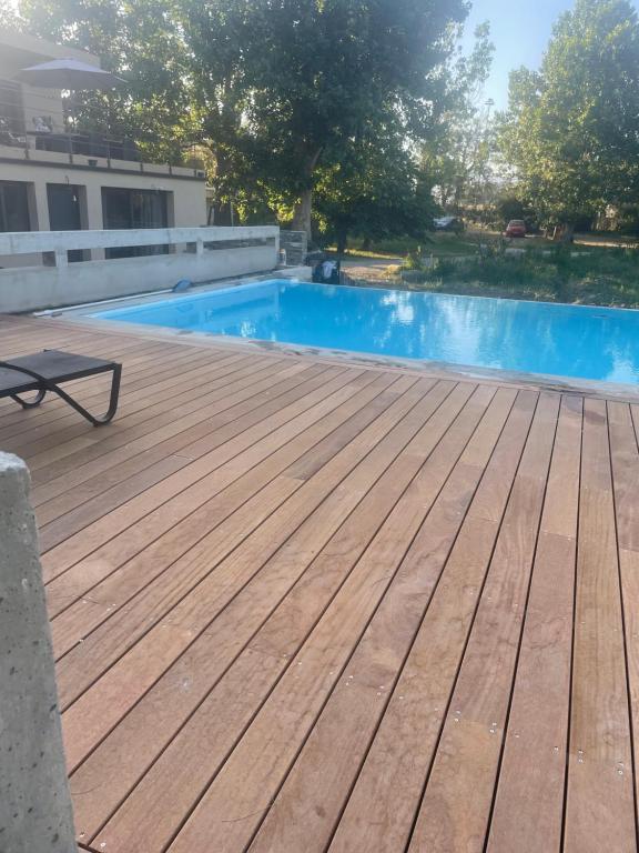 a wooden deck with a swimming pool in front of a building at Charmante Propriété Arborée in Borgo
