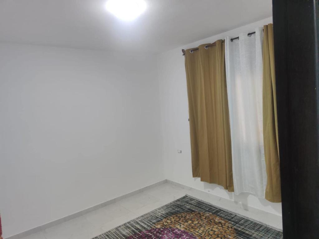 y baño con cortina de ducha y alfombra. en Golden House en Ramallah