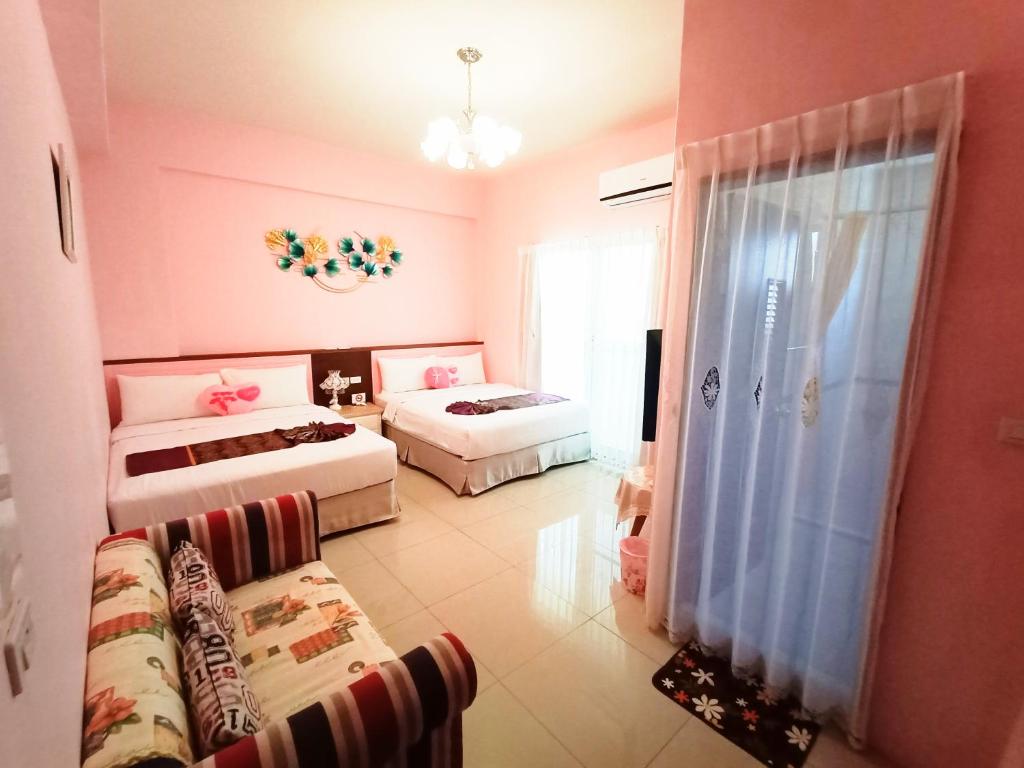 ein Wohnzimmer mit 2 Betten und einem Sofa in der Unterkunft Harbourview in Taitung