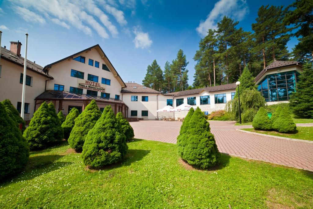 rząd drzew przed budynkiem w obiekcie Hotel Perła Bieszczadów Geovita w mieście Czarna