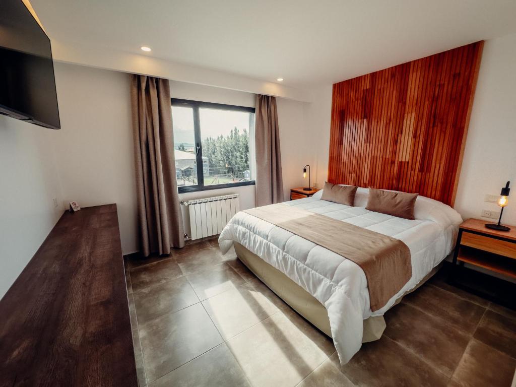 a bedroom with a large bed and a large window at Destino Calafate in El Calafate