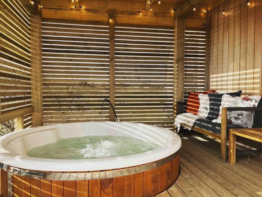 une baignoire jacuzzi dans une chambre avec banc dans l'établissement The Grimsay Cabin, à Carinish