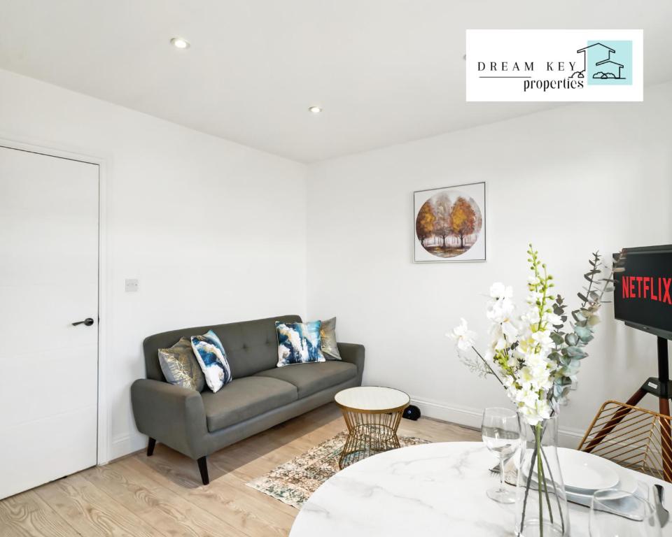 a living room with a couch and a table at One Bedroom Apartment by Dream Key Properties Short Lets & Long Lets Uxbridge with Free Wi-fi - 5 in Uxbridge