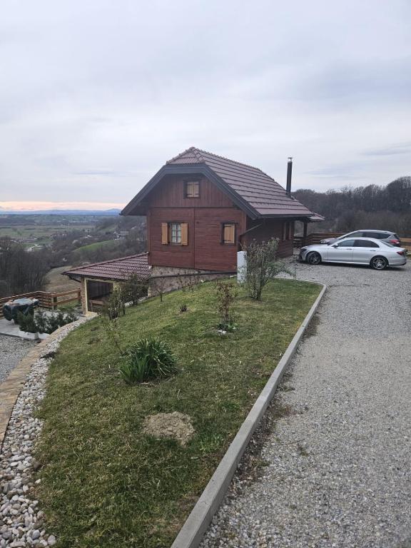 a house on a hill with a car parked next to it at Kuća sa bazenom za odmor i domjenke MARIS in Gornji Kraj