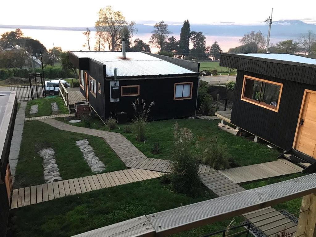 a small black house with a pathway leading to it at Vistaranco Costanera in Lago Ranco