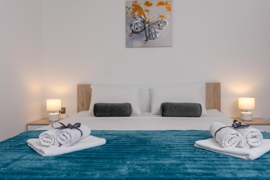 a bedroom with a bed with towels on it at Blue Mile Apartman Split in Split