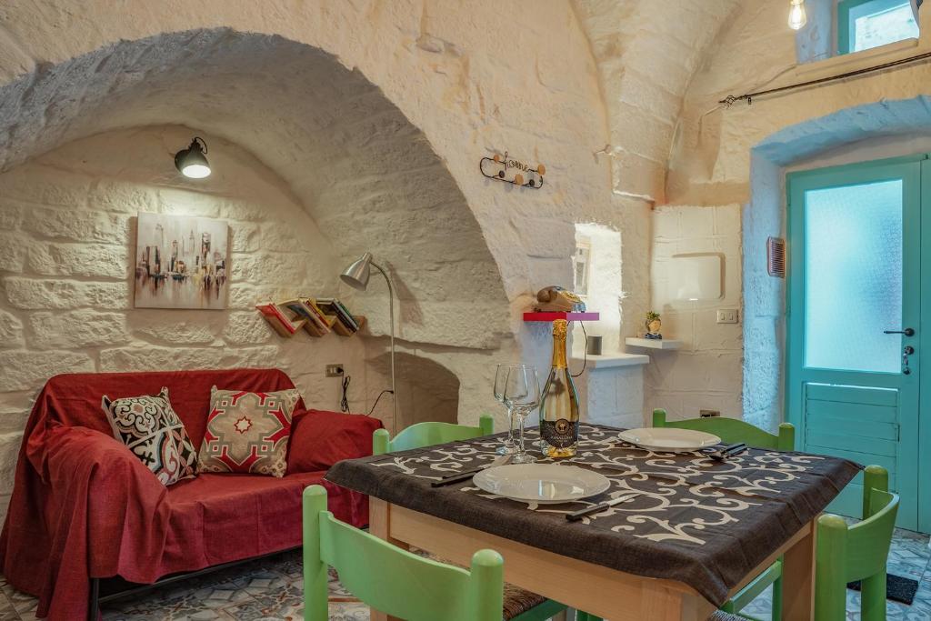 comedor con sofá rojo y mesa en Casa Vacanze “House on the Left”, en Ceglie Messapica