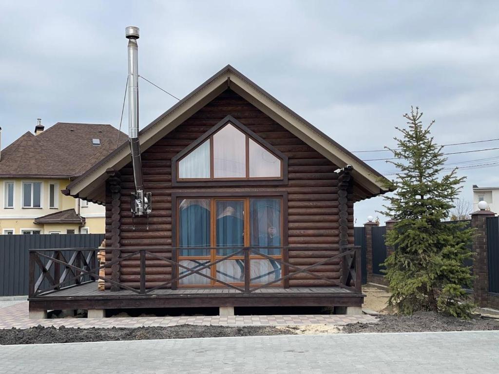 a log cabin with a window in a yard at Затишний котедж в Білогородці in Belogorodka