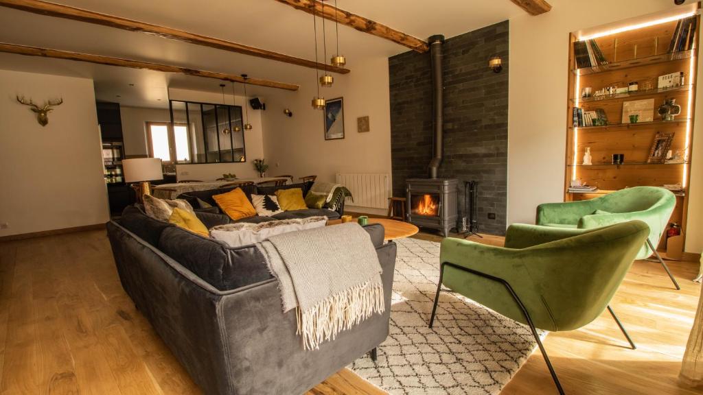 a living room with a couch and chairs and a fireplace at Chalet Peak Noir entier 12pers - Cosy House Peak Noir for 12people in Le Monêtier-les-Bains