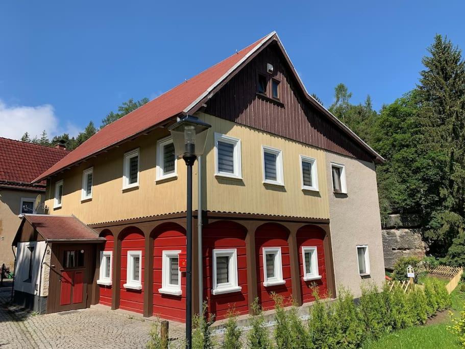 HainにあるWaldferienhaus Dunja mit Whirlpool, Sauna u Gartenの赤い扉と柱の大きな建物