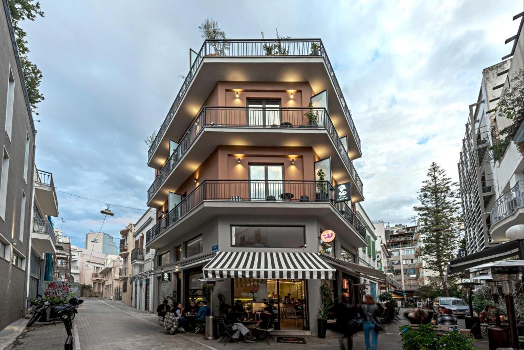 ein hohes Gebäude mit Balkon in einer Stadtstraße in der Unterkunft Clyde Athens by Nin&Bau in Athen